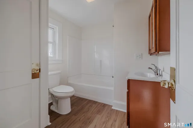a bathroom with a sink toilet a mirror and bathtub