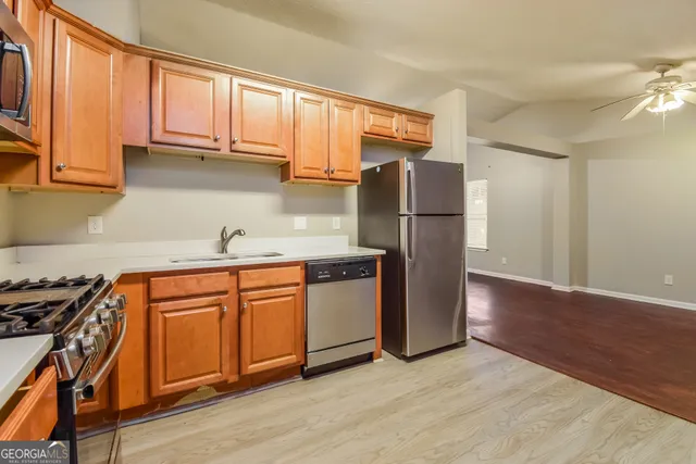 a kitchen with stainless steel appliances granite countertop a refrigerator sink and cabinets