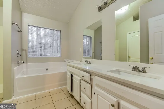 a bathroom with a tub sink and a mirror