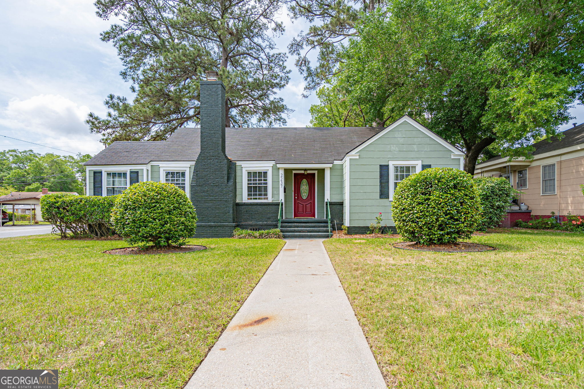 a front view of a house with yard and green space