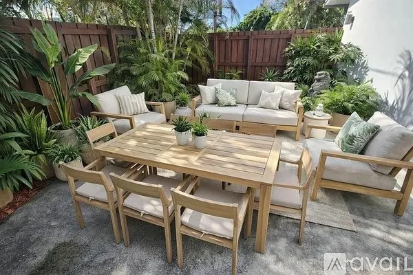 a view of a backyard with furniture and wooden fence