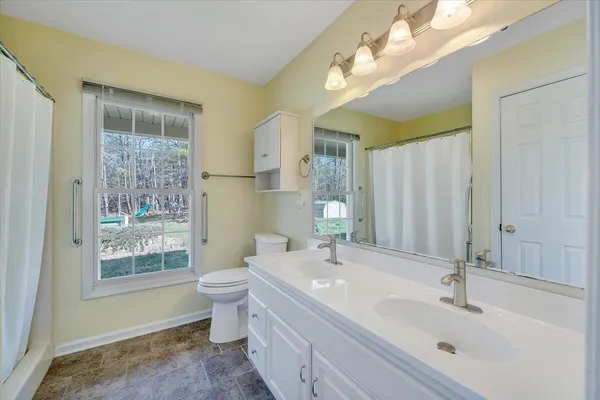 a view of a house with a yard and large tree