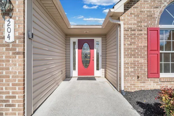 a view of an empty room with wooden floor and window