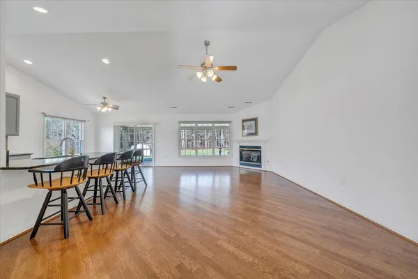 a kitchen with stainless steel appliances kitchen island granite countertop a table chairs and a refrigerator