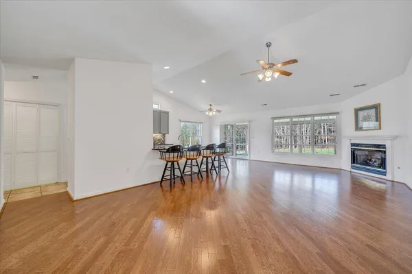 a kitchen with stainless steel appliances granite countertop a sink a stove a refrigerator and island with wooden floor