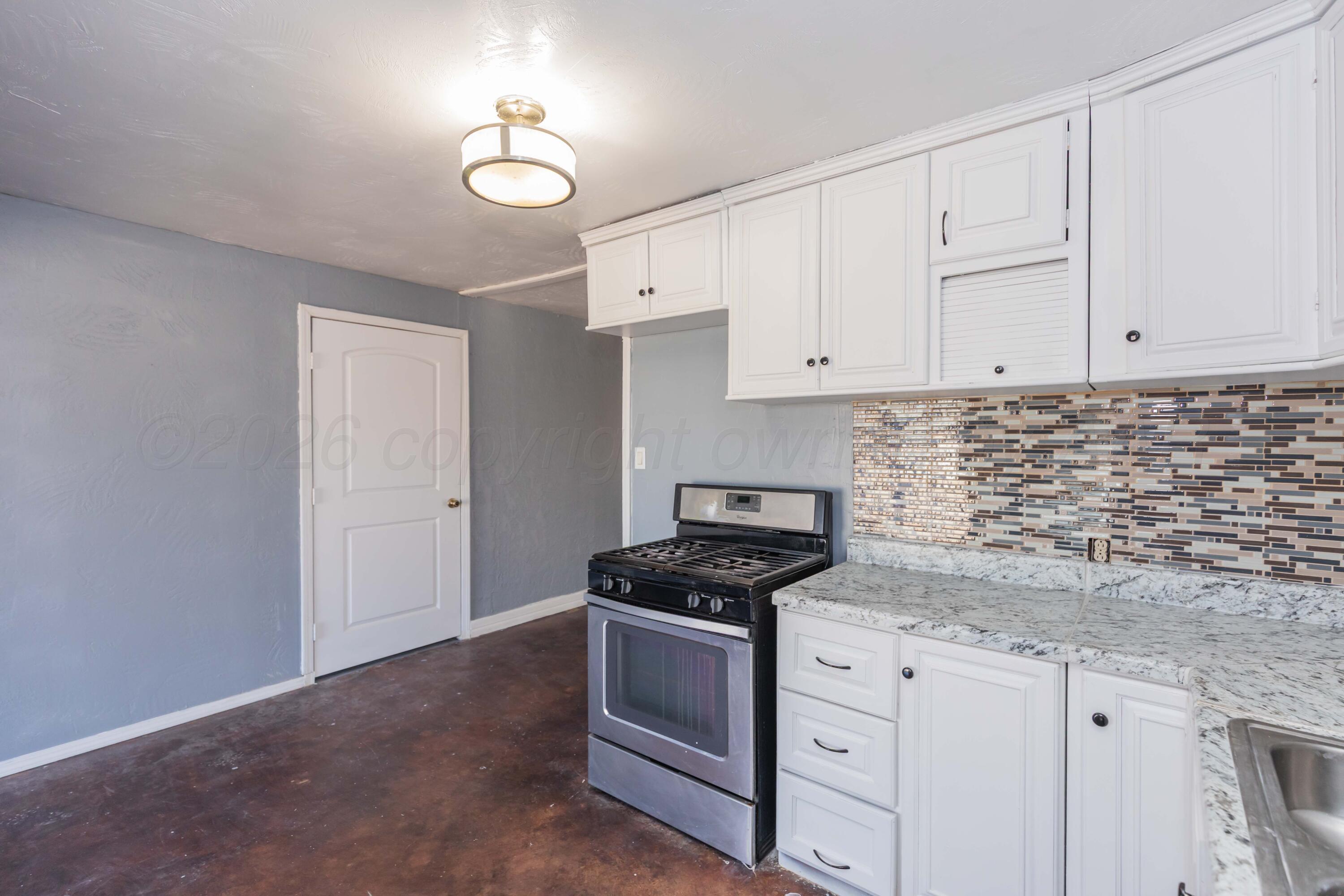 1811 North Wilson Street Amarillo, TX 79107 - Photo 10 of 27 a kitchen with granite countertop white cabinets and white appliances