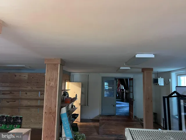 a view of a hallway with wooden floor and closet