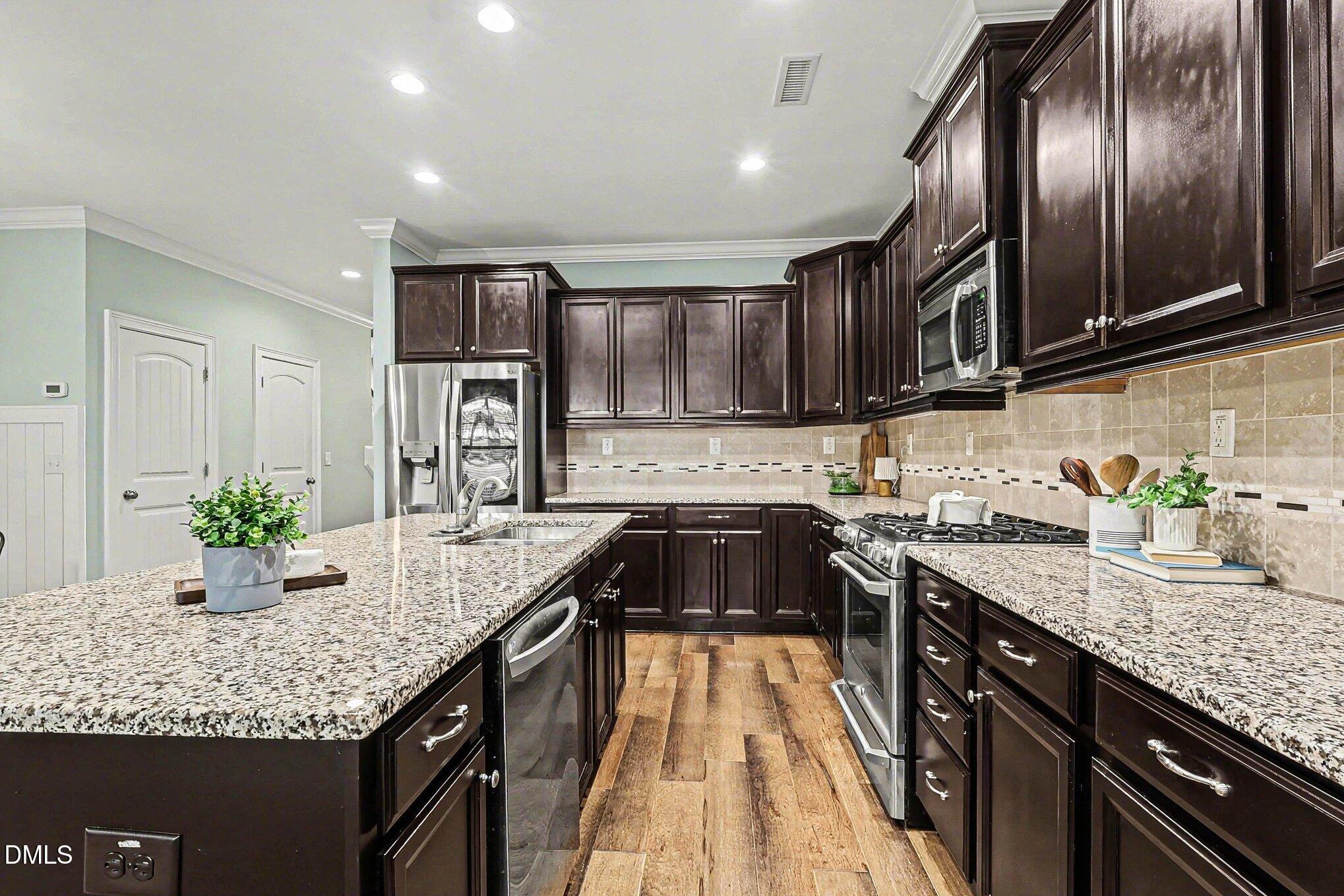653 Fallon Grove Way Raleigh, NC 27608 - Photo 7 of 38 a kitchen with granite countertop stainless steel appliances and sink