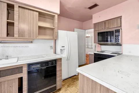 a kitchen with stainless steel appliances a stove a sink and a refrigerator
