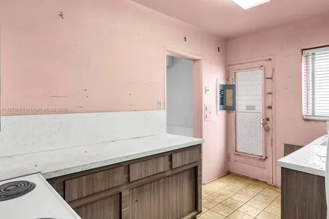 a kitchen with a sink a refrigerator and cabinets