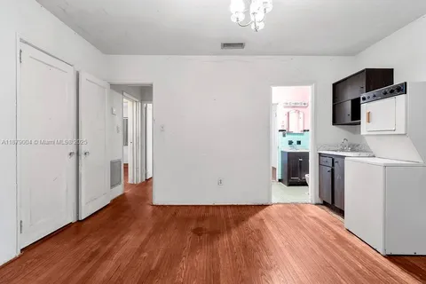 a view of a kitchen with wooden floor and a refrigerator