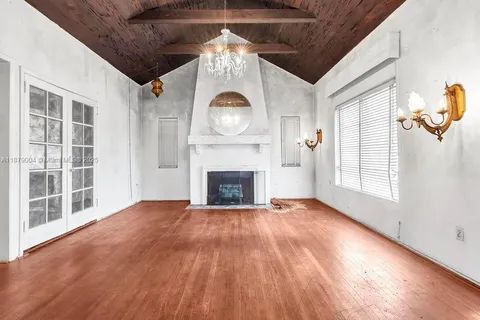 a view of an empty room with a fireplace and a window