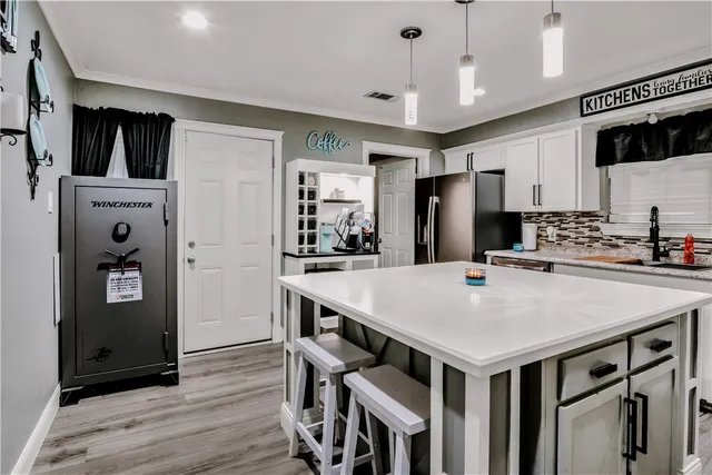 a kitchen that has a lot of cabinets a sink and wooden floor