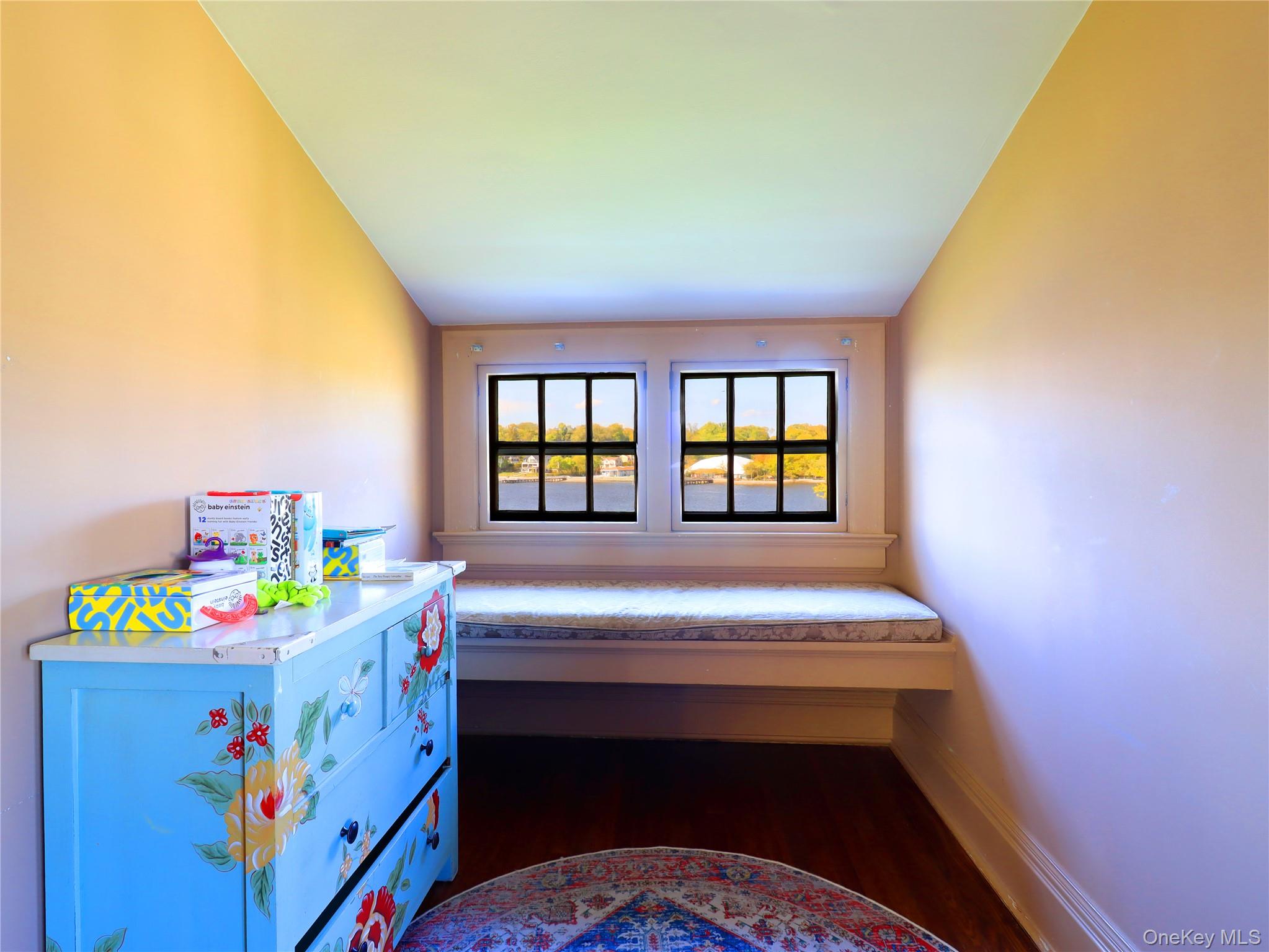 11-20 Shore Road Queens, NY 11363 - Photo 40 of 45 Window seat with built-in storage, dual windows with black mullions, wood-finish flooring, and sloped ceiling