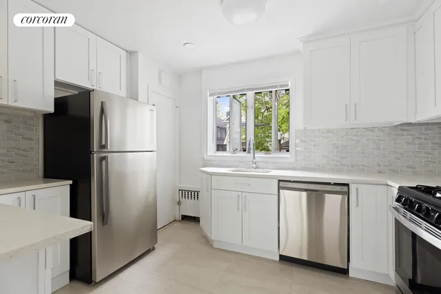 a kitchen with white cabinets and refrigerator