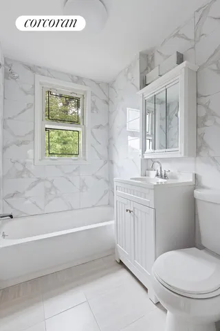 a bathroom with a granite countertop toilet a sink and bathtub