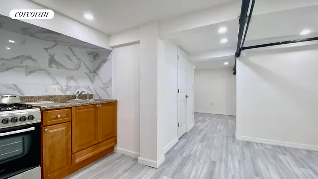 a view of a kitchen with a sink wooden floor and stainless steel appliances