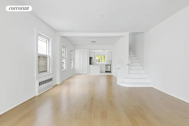 a view of empty room with wooden floor and window