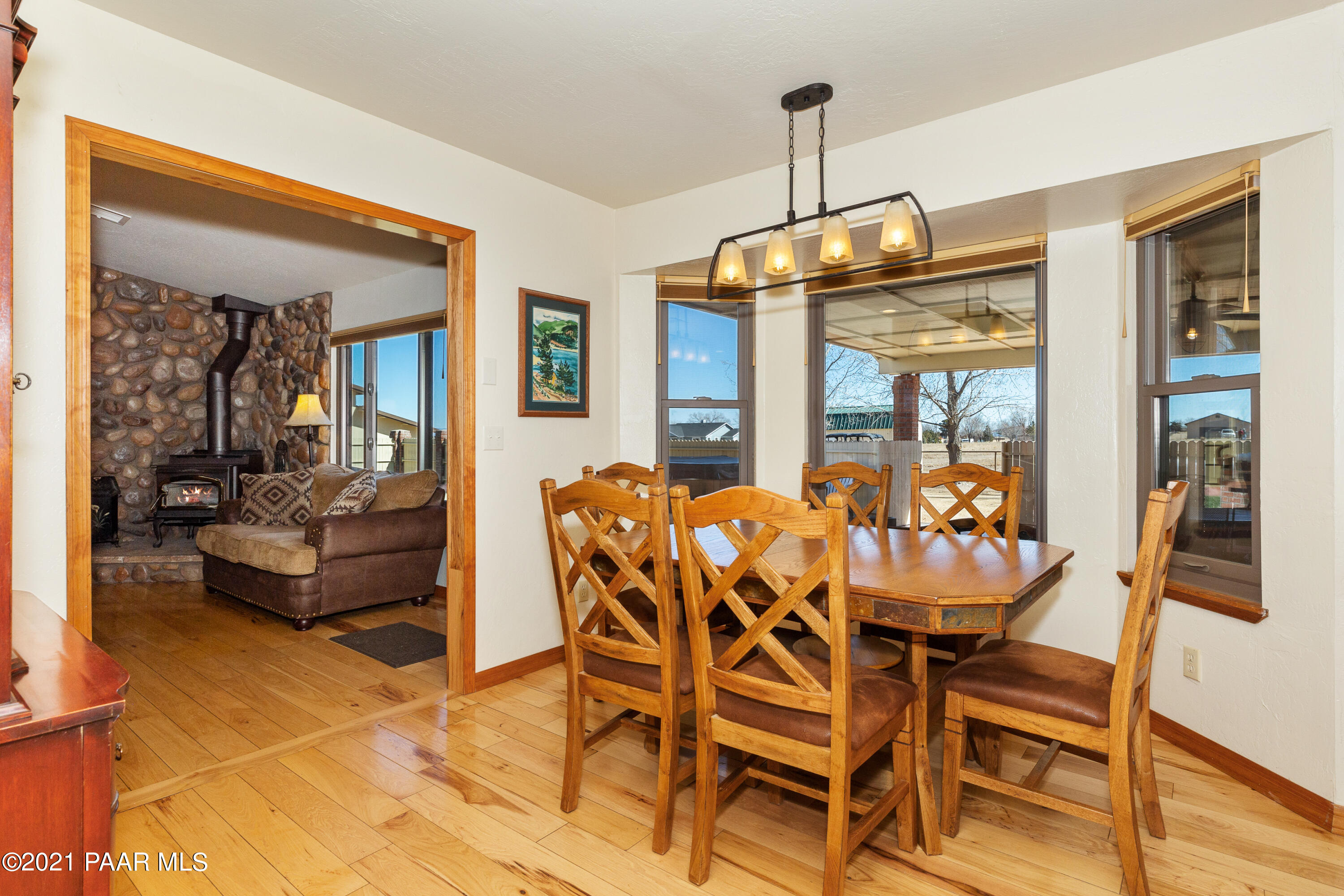 3727 North Reed Road Chino Valley, AZ 86323 - Photo 6 of 45 a dining room with furniture a chandelier and wooden floor