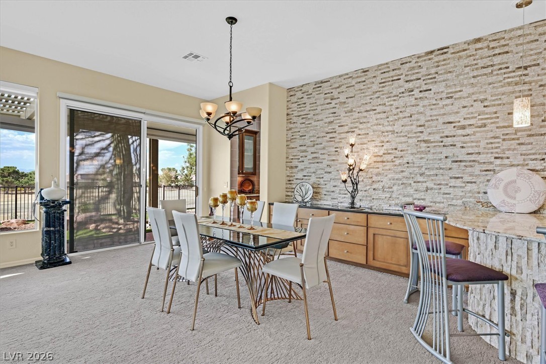 1823 Baton Rouge Street Henderson, NV 89052 - Photo 11 of 60 A textured stone wall anchors this open dining space equipped with large sliding glass doors.