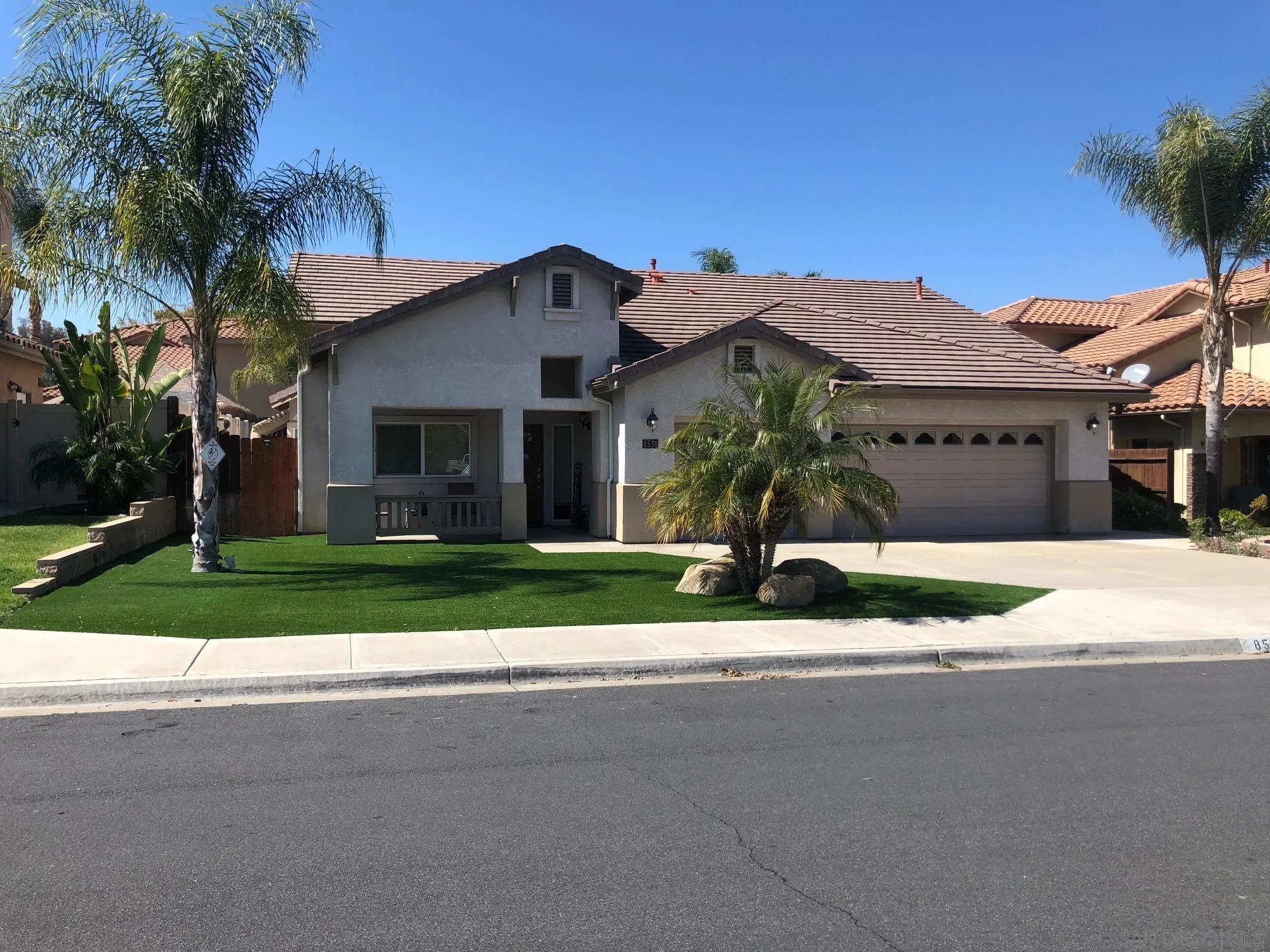 a front view of a house with a garden and plants