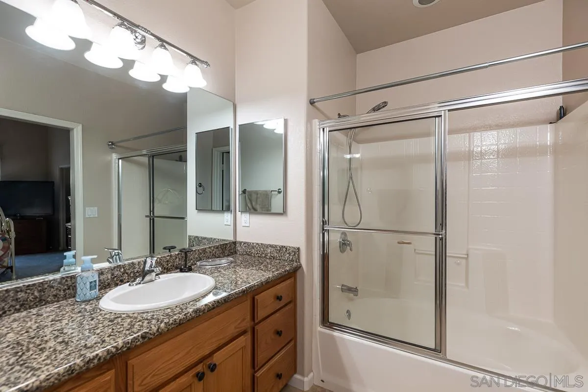 8538 Paseo De Los Castillos Santee, CA 92071 - Photo 11 of 20 a bathroom with a granite countertop shower sink and mirror