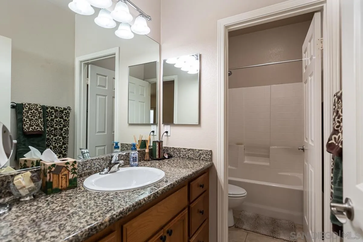 8538 Paseo De Los Castillos Santee, CA 92071 - Photo 15 of 20 a bathroom with a granite countertop sink mirror and a bathtub