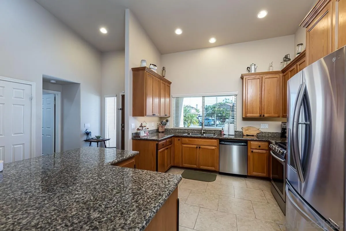 8538 Paseo De Los Castillos Santee, CA 92071 - Photo 7 of 20 a large kitchen with stainless steel appliances granite countertop a sink stove and refrigerator