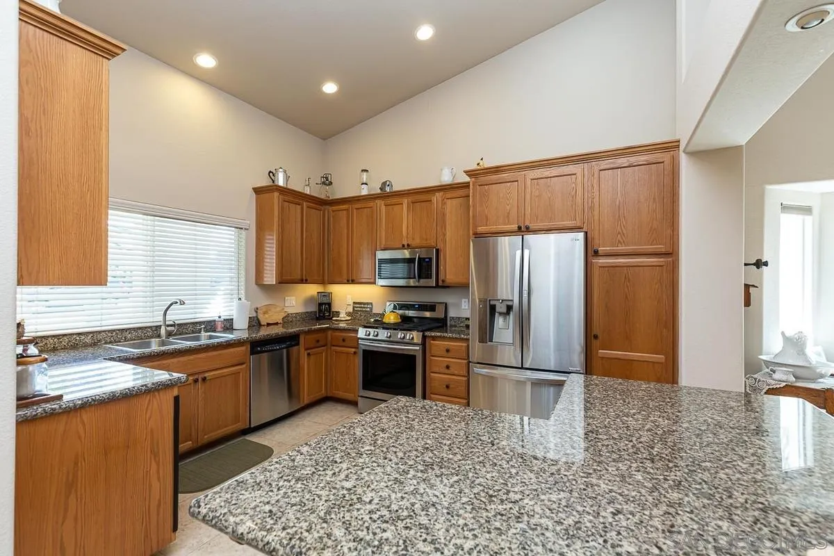8538 Paseo De Los Castillos Santee, CA 92071 - Photo 8 of 20 a kitchen with granite countertop stainless steel appliances and wooden cabinets