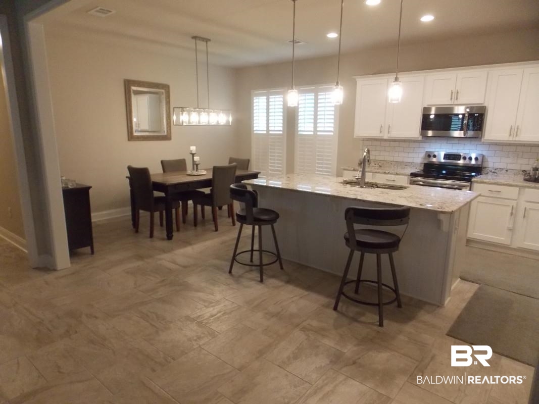 1121 Stella Road Foley, AL 36535 - Photo 6 of 22 Kitchen featuring stainless steel appliances, white cabinetry, a center island with sink, and sink