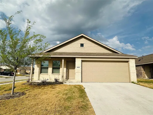 a front view of a house with a yard and garage