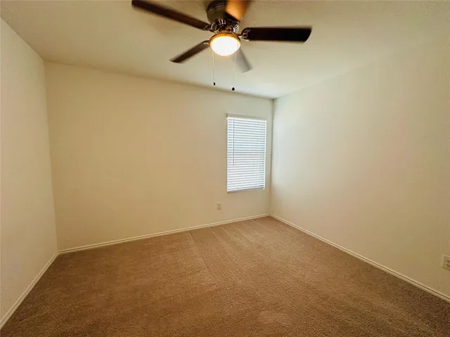 an empty room with a fan and a ceiling fan