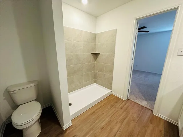 a bathroom with a toilet and a shower
