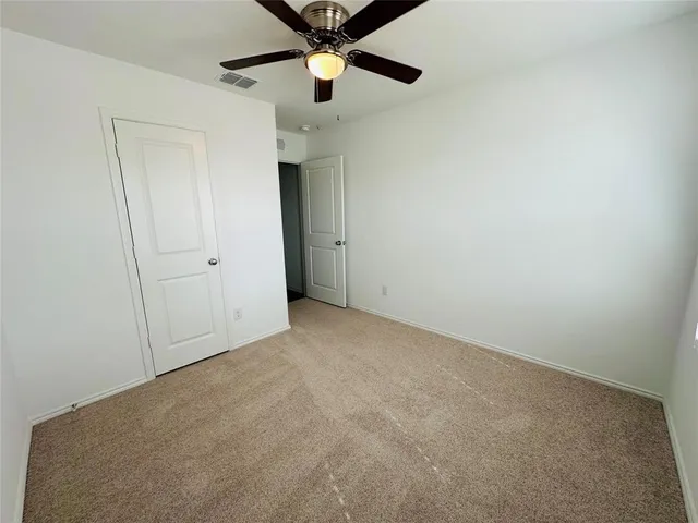 an empty room with chandelier fan