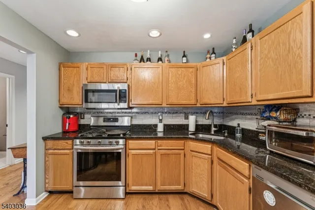 a kitchen with stainless steel appliances granite countertop a stove a sink and a microwave