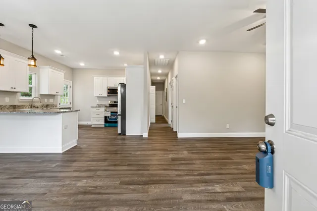 a view of kitchen with kitchen island white cabinets and stainless steel appliances