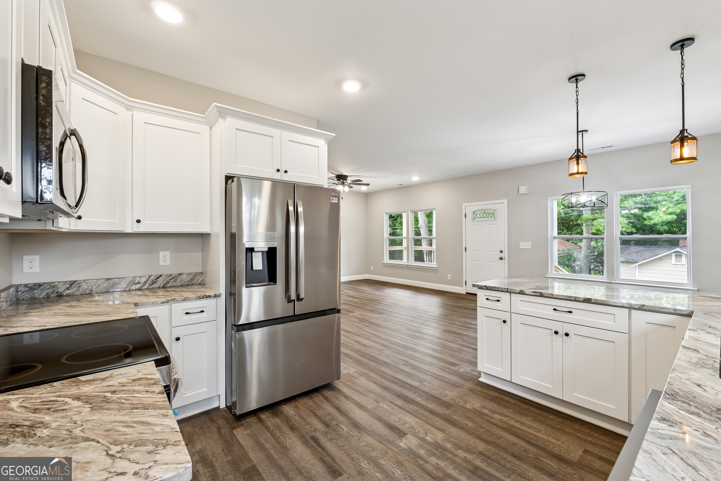 111 Hosea Street Rome, GA 30161 - Photo 8 of 14 a kitchen with stainless steel appliances granite countertop a refrigerator a stove a sink and white cabinets with wooden floor