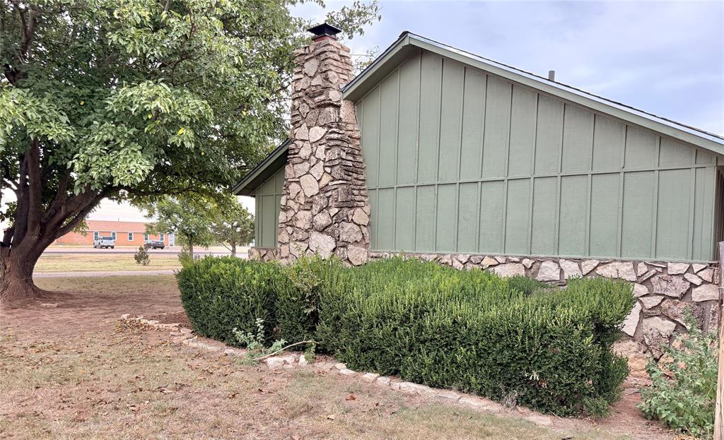 504 Loop Road Quanah, TX 79252 - Photo 7 of 40 View of property exterior with board and batten siding, stone siding, and a chimney