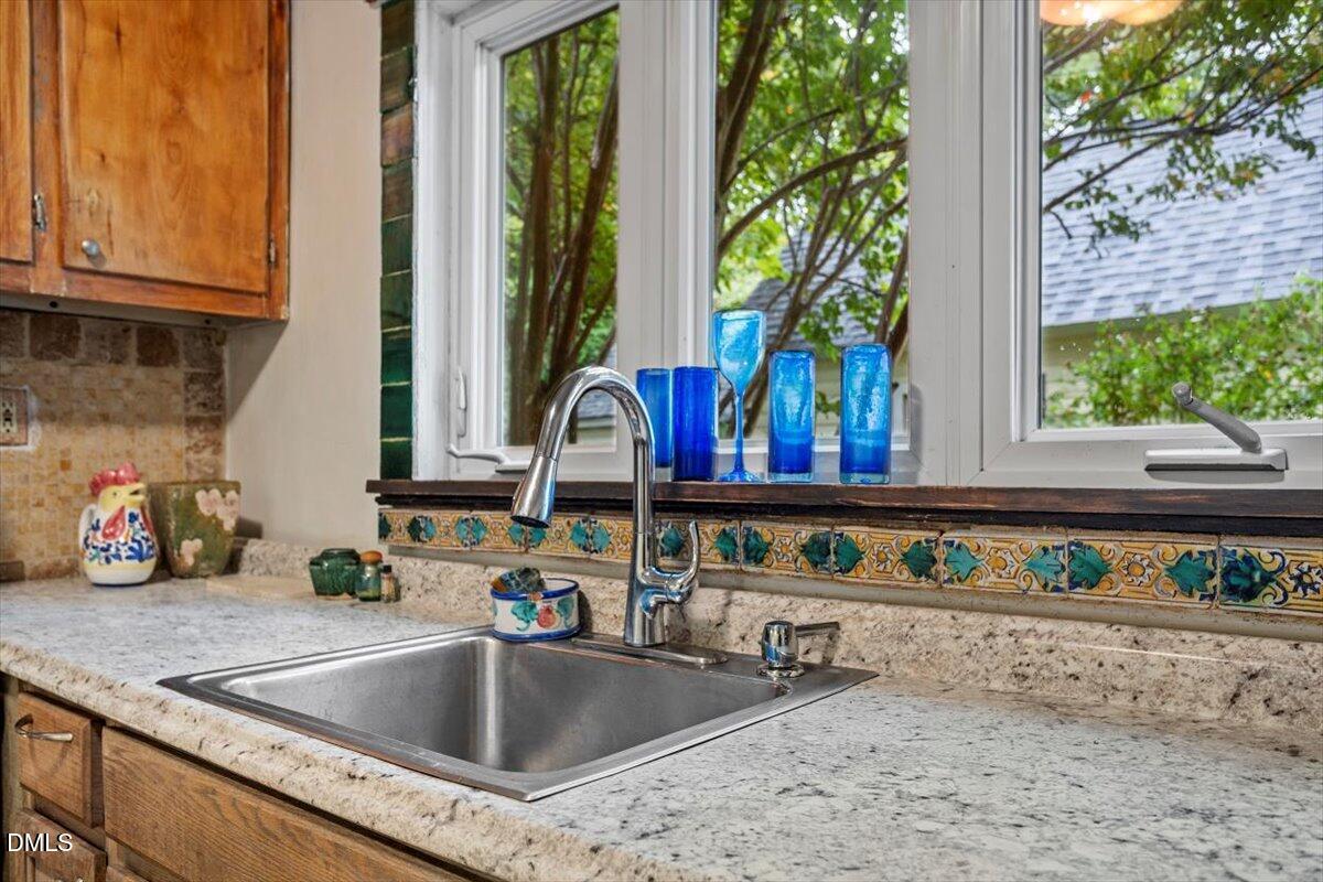 206 North State Street Raleigh, NC 27601 - Photo 15 of 21 Bright and inviting kitchen featuring custom tile accents, sleek stainless steel appliancesāincluding refrigerator and rangeāand new, charming (crank) windows that fill the space with natural light and tiled floor.