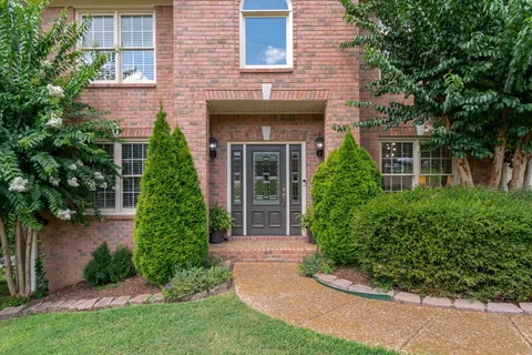 front view of a house with a yard and potted plants