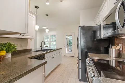 a large kitchen with a table and chairs