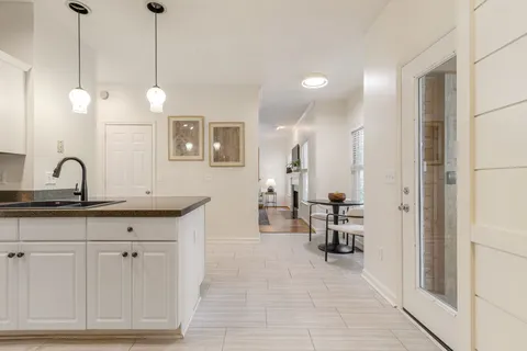 an empty room with windows and chandelier fan