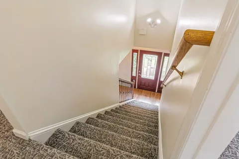 a view of a hallway with wooden floor and closet