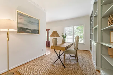 a view of a workspace with furniture and a window