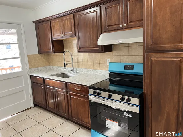 a kitchen with granite countertop a cabinets sink and stove
