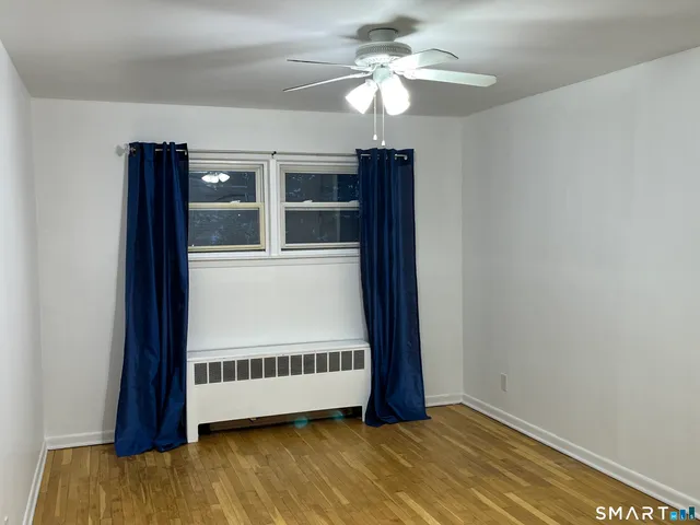a view of an empty room with a window and closet
