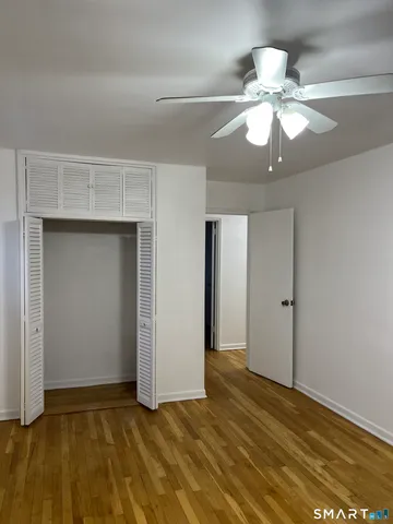 a view of an empty room with a chandelier fan