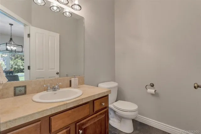 a bathroom with a granite countertop sink a toilet and a mirror