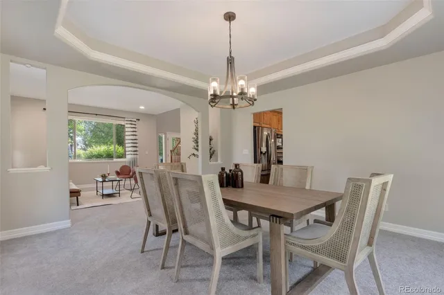 a view of a dining room with furniture and chandelier