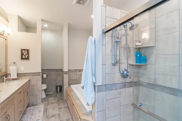 a bathroom with a double vanity sink toilet and shower